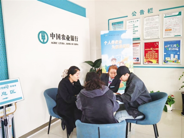 工作人员向群众介绍社？ò炖硎褂檬乱。