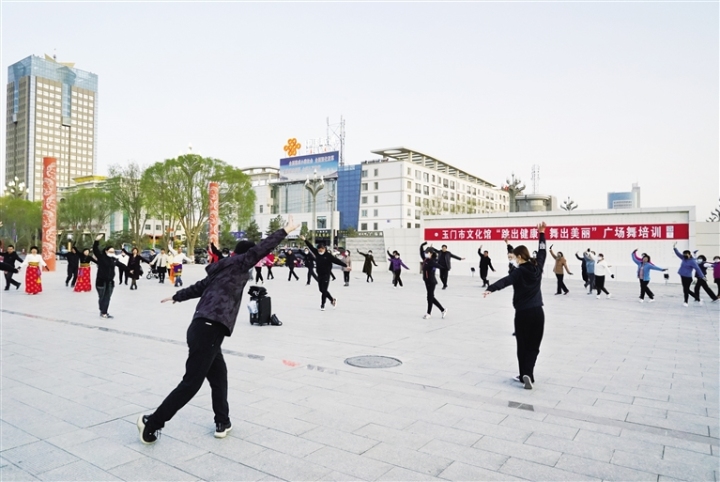 文艺志愿者教群众跳广场舞。